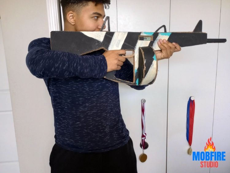 Teen-created cardboard AA-12 shotgun with non-removable drum mag